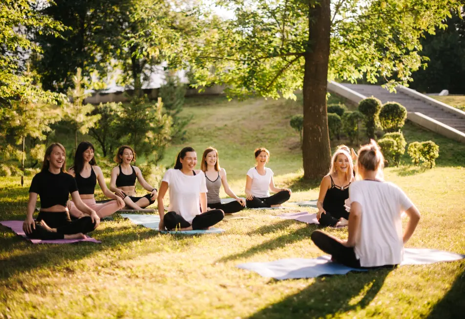 Group yoga session on a sunny lawn